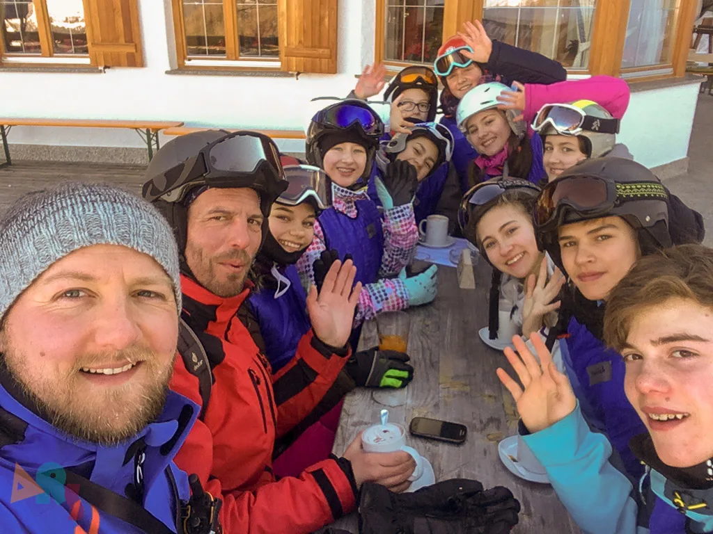 Jugendliche winken beim Selbstporträt vor der Hütte.